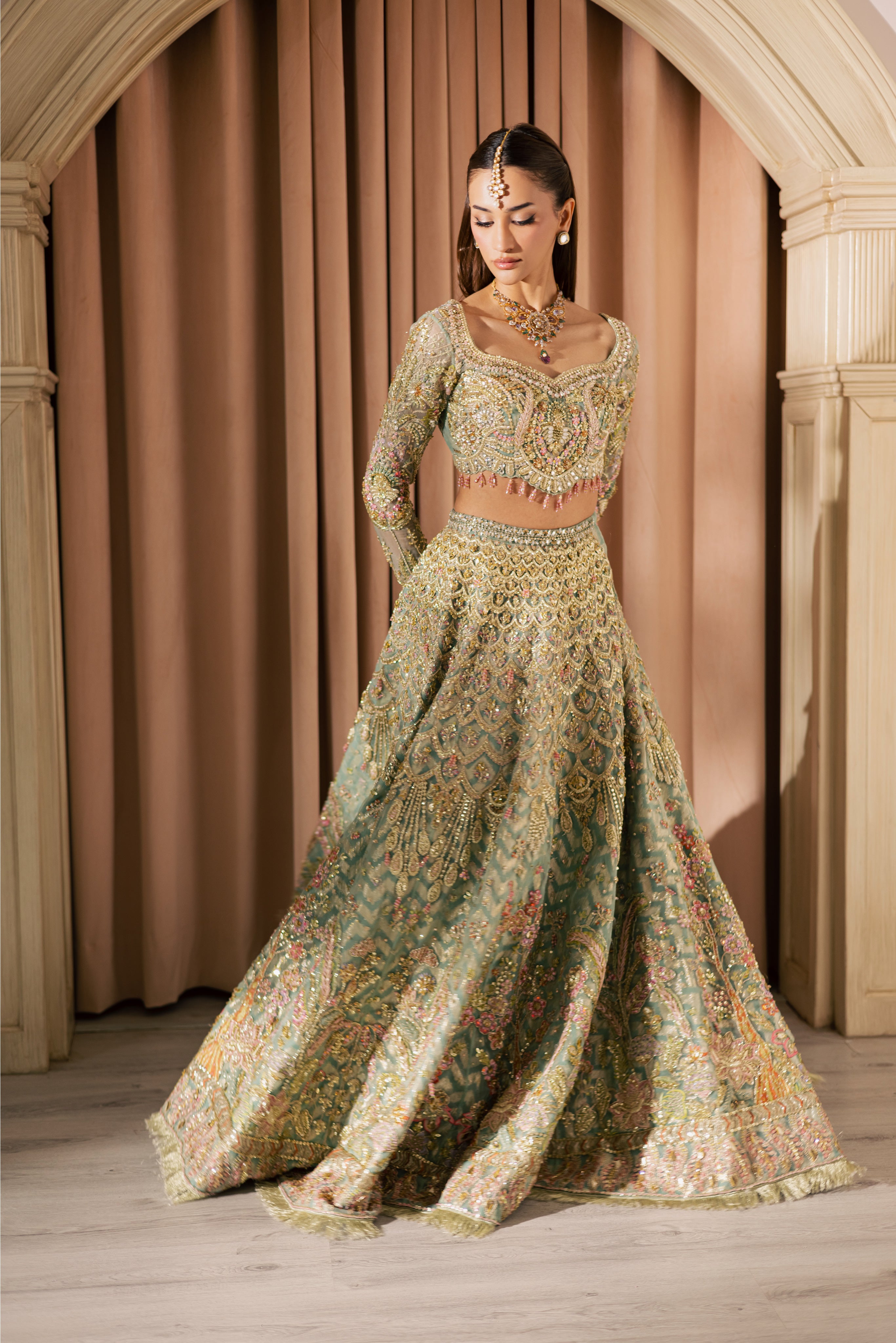 Luxury gold and pastel net Pakistani bridal lehenga by Mysie by Tahira, featuring intricate hand embellishment and couture detailing.