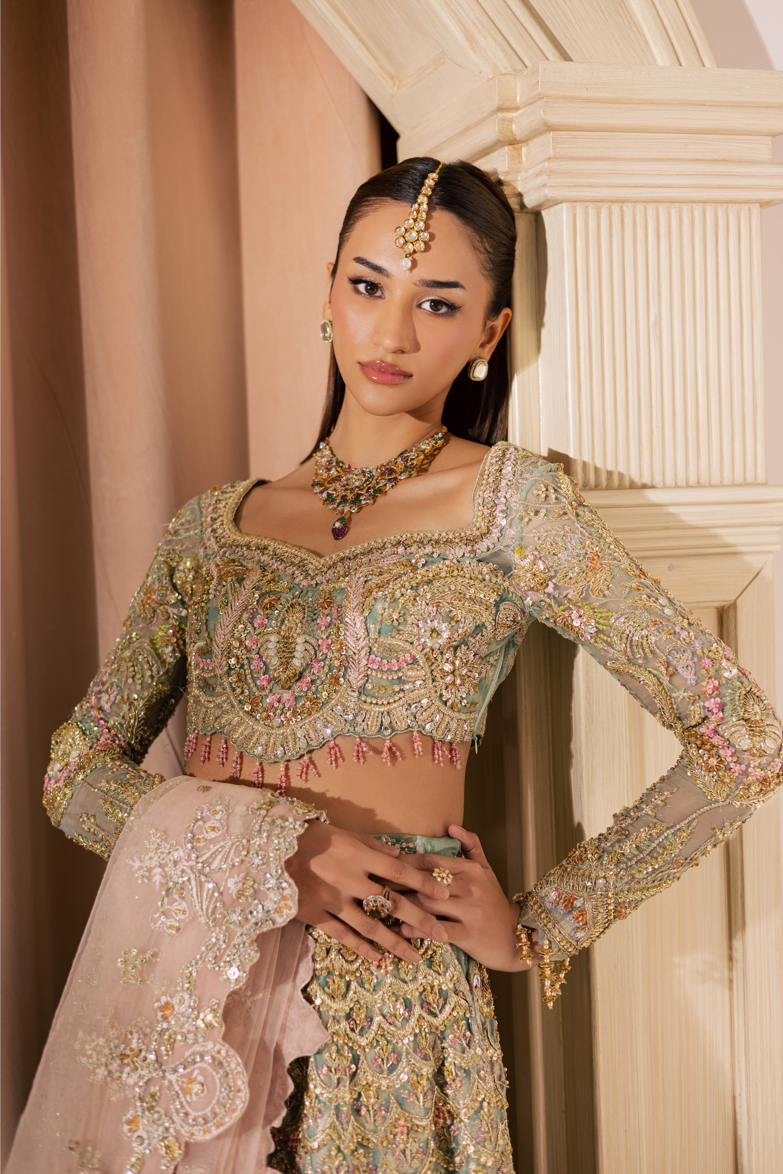 Luxury gold and pastel net Pakistani bridal lehenga by Mysie by Tahira, featuring intricate hand embellishment and couture detailing.