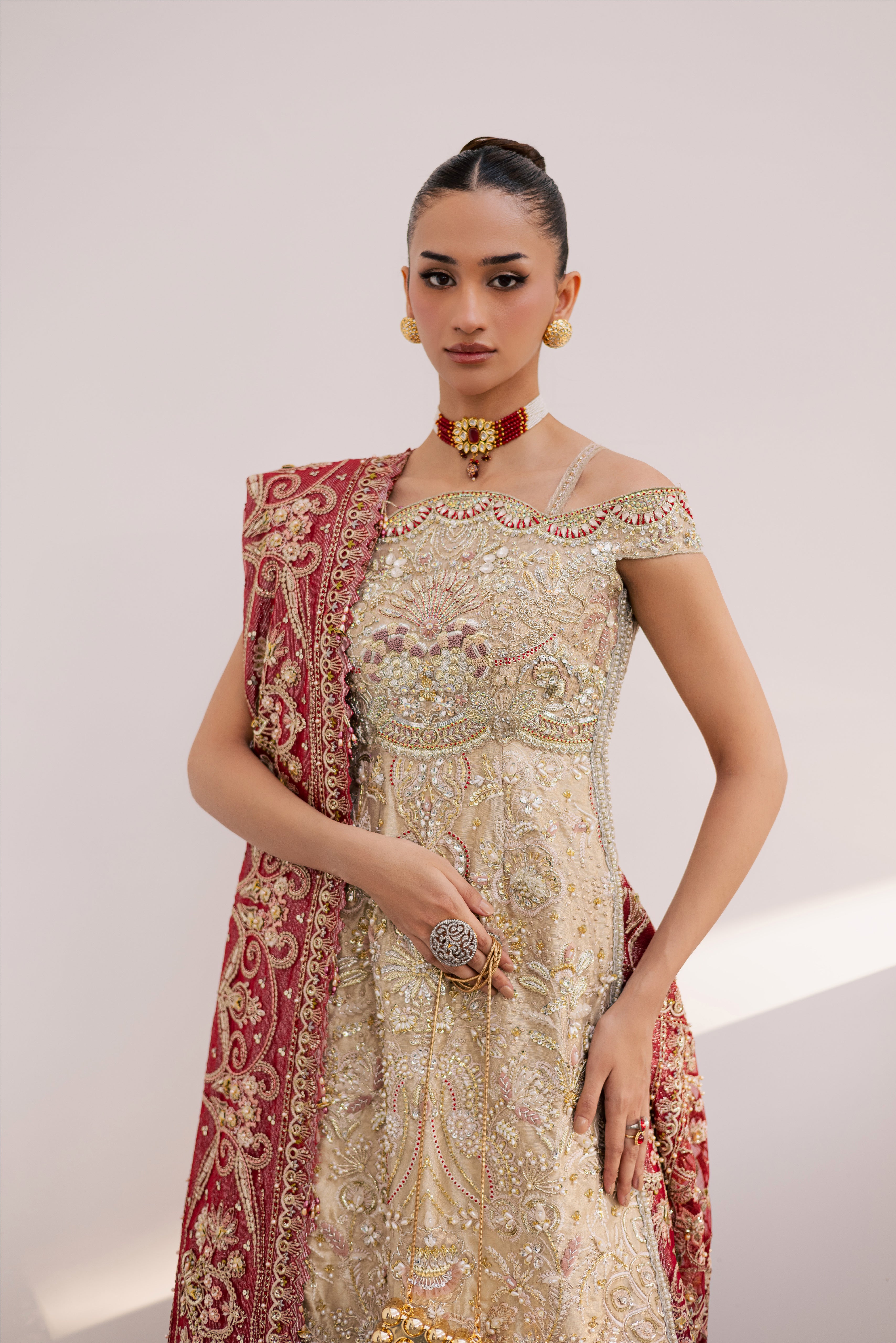 Model wearing champagne gold hand-embellished shirt and lehenga with rich maroon dupatta, luxury Pakistani couture by Mysie by Tahira.