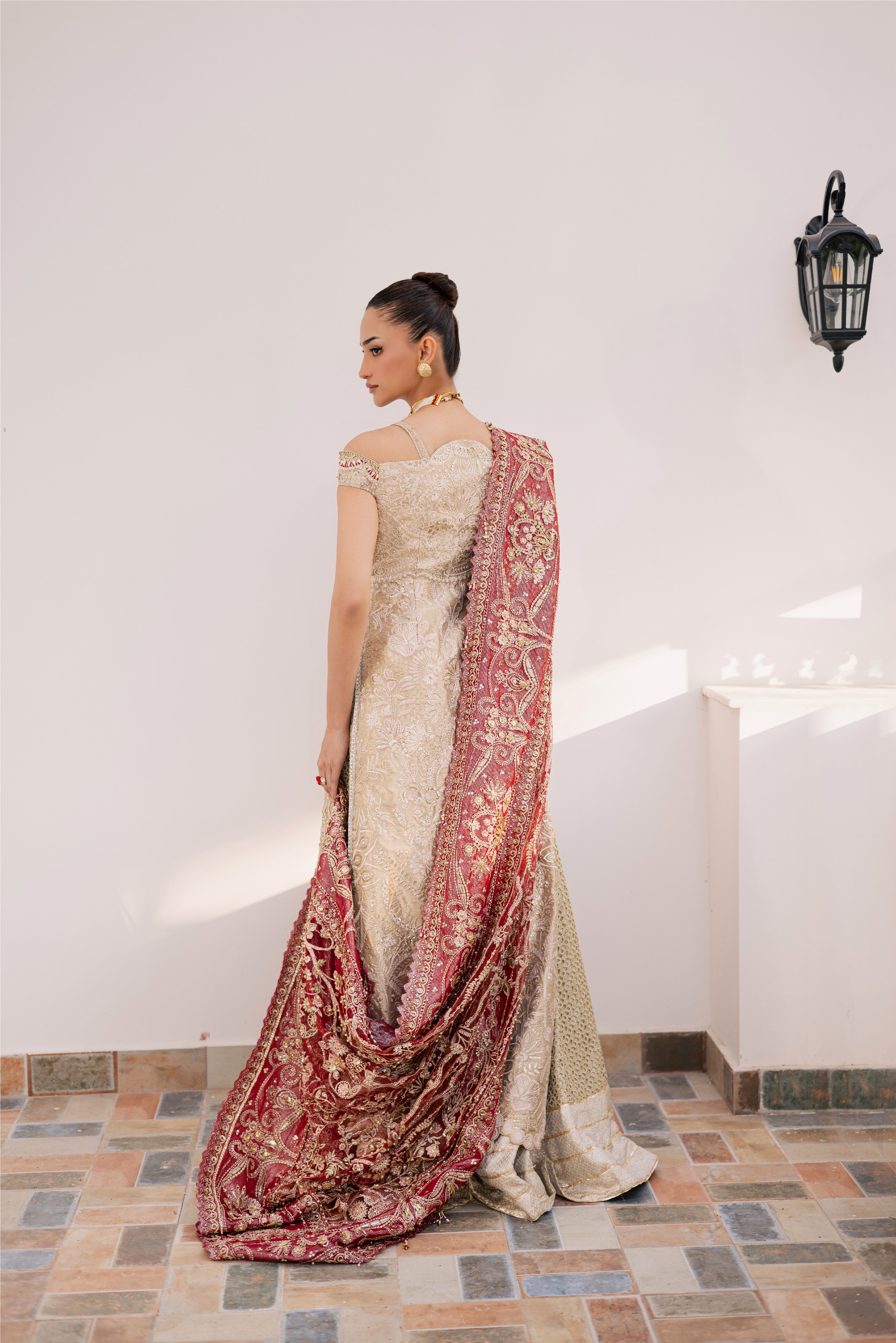 Model wearing champagne gold hand-embellished shirt and lehenga with rich maroon dupatta, luxury Pakistani couture by Mysie by Tahira.