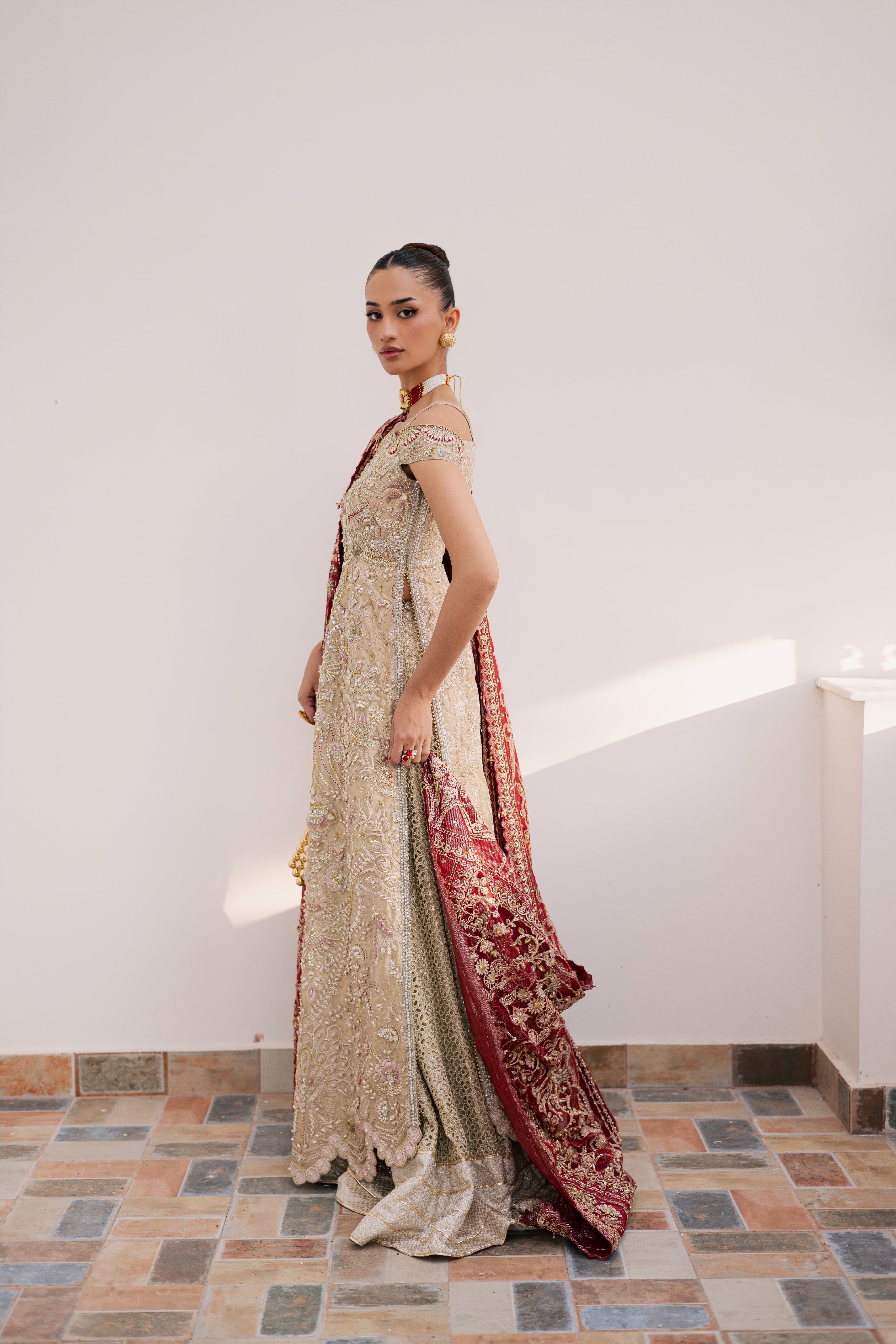 Model wearing champagne gold hand-embellished shirt and lehenga with rich maroon dupatta, luxury Pakistani couture by Mysie by Tahira.