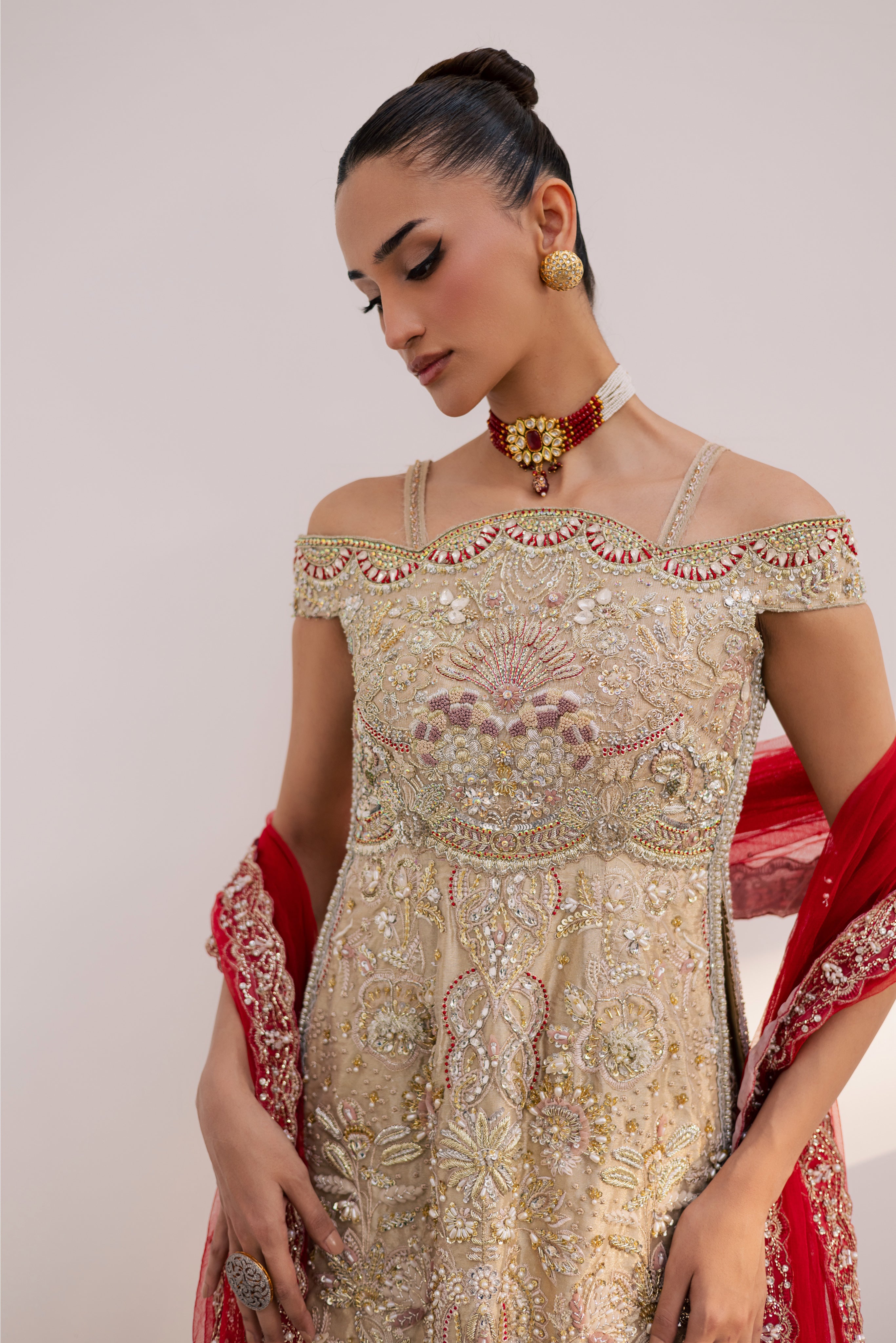Model wearing champagne gold hand-embellished shirt and lehenga with rich maroon dupatta, luxury Pakistani couture by Mysie by Tahira.