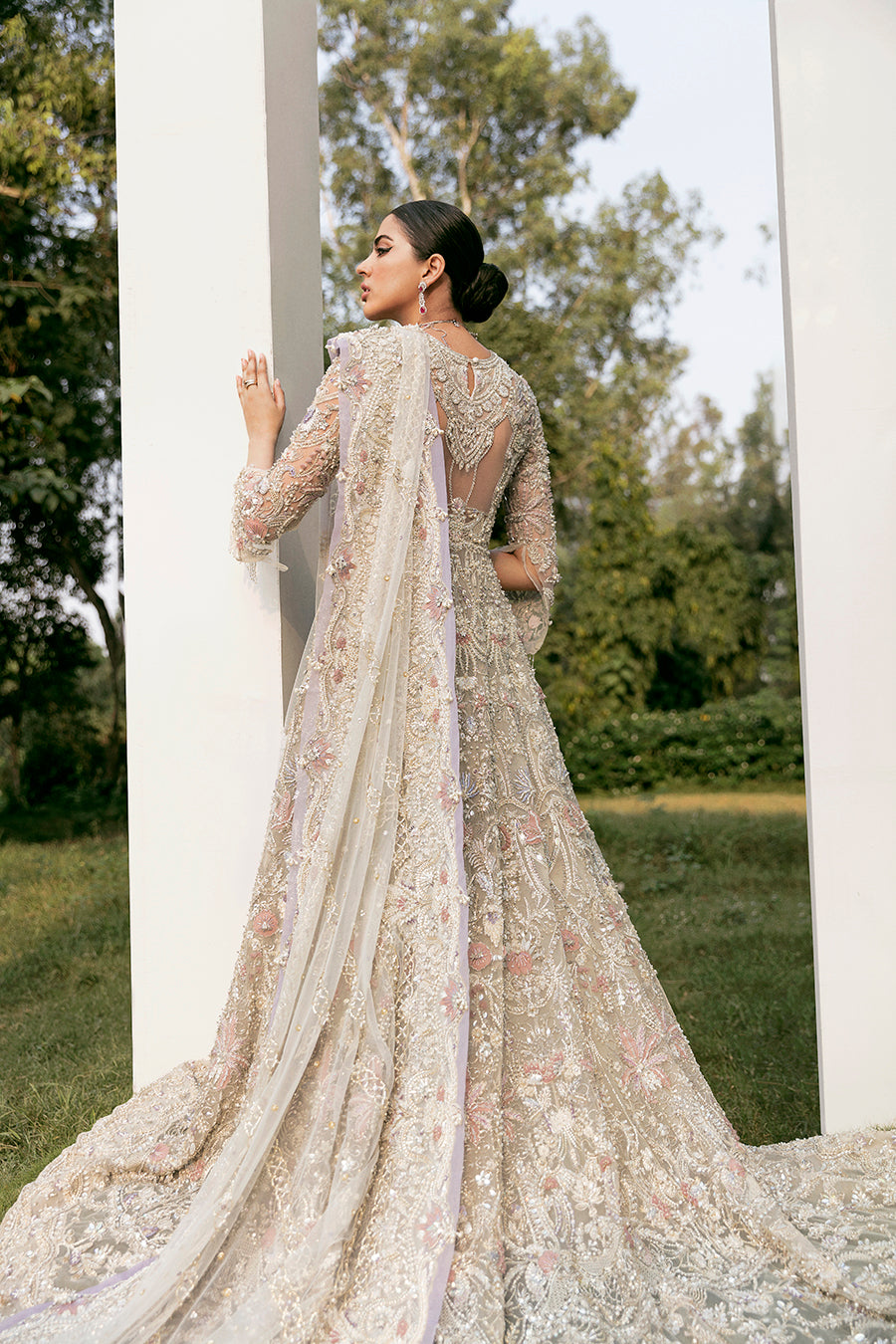 Bridal elegance in Calipso gown, showcasing the dramatic net trail, raw-silk lehenga, and lavender accents.