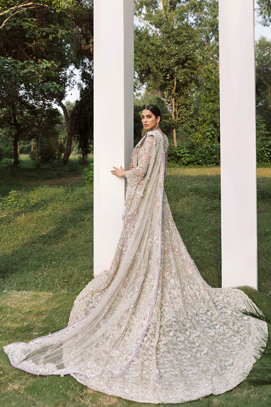 Bridal elegance in Calipso gown, showcasing the dramatic net trail, raw-silk lehenga, and lavender accents.