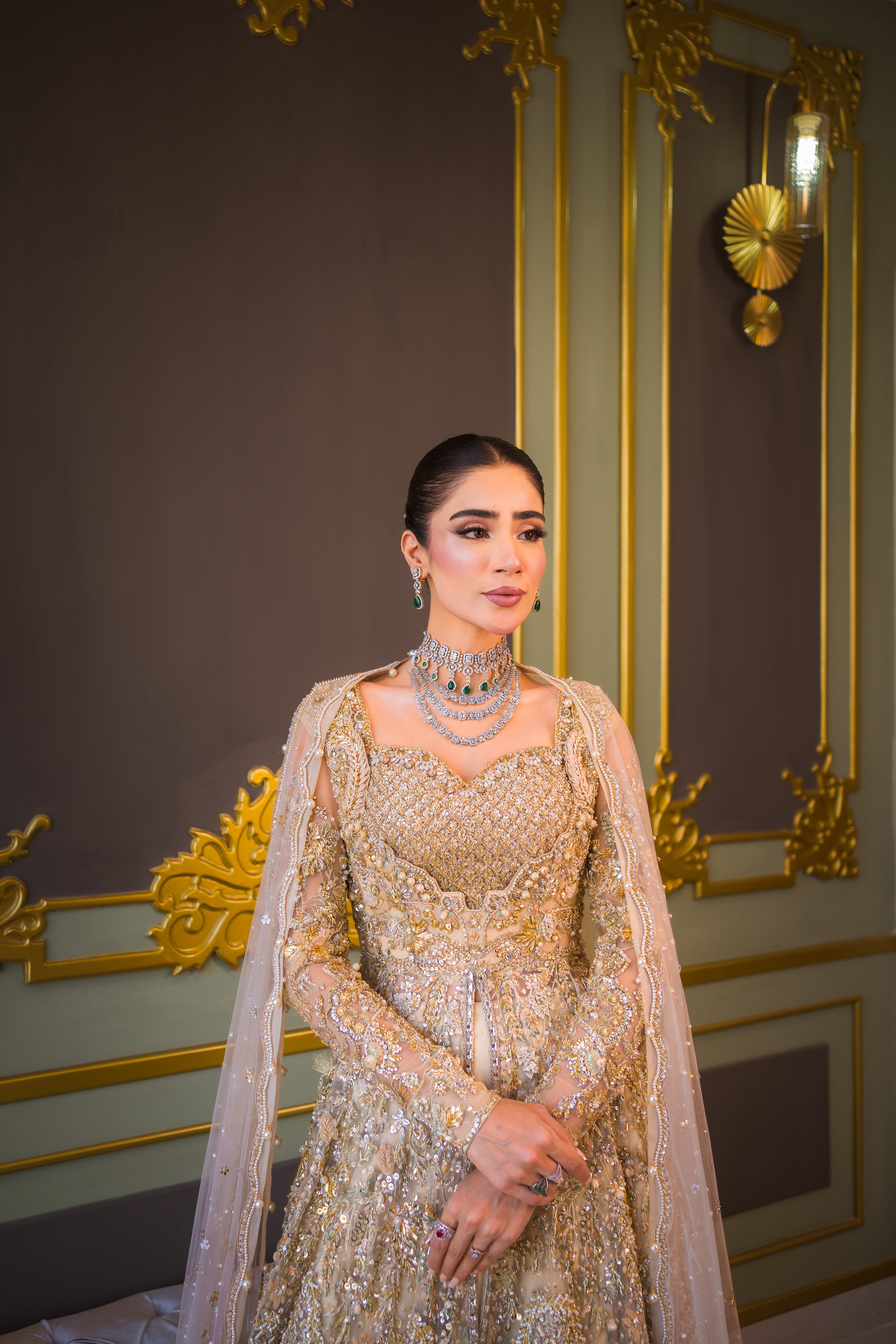 Luxury Pakistani bridal outfit Biana in subtle gold net fabric with hand embellishments.