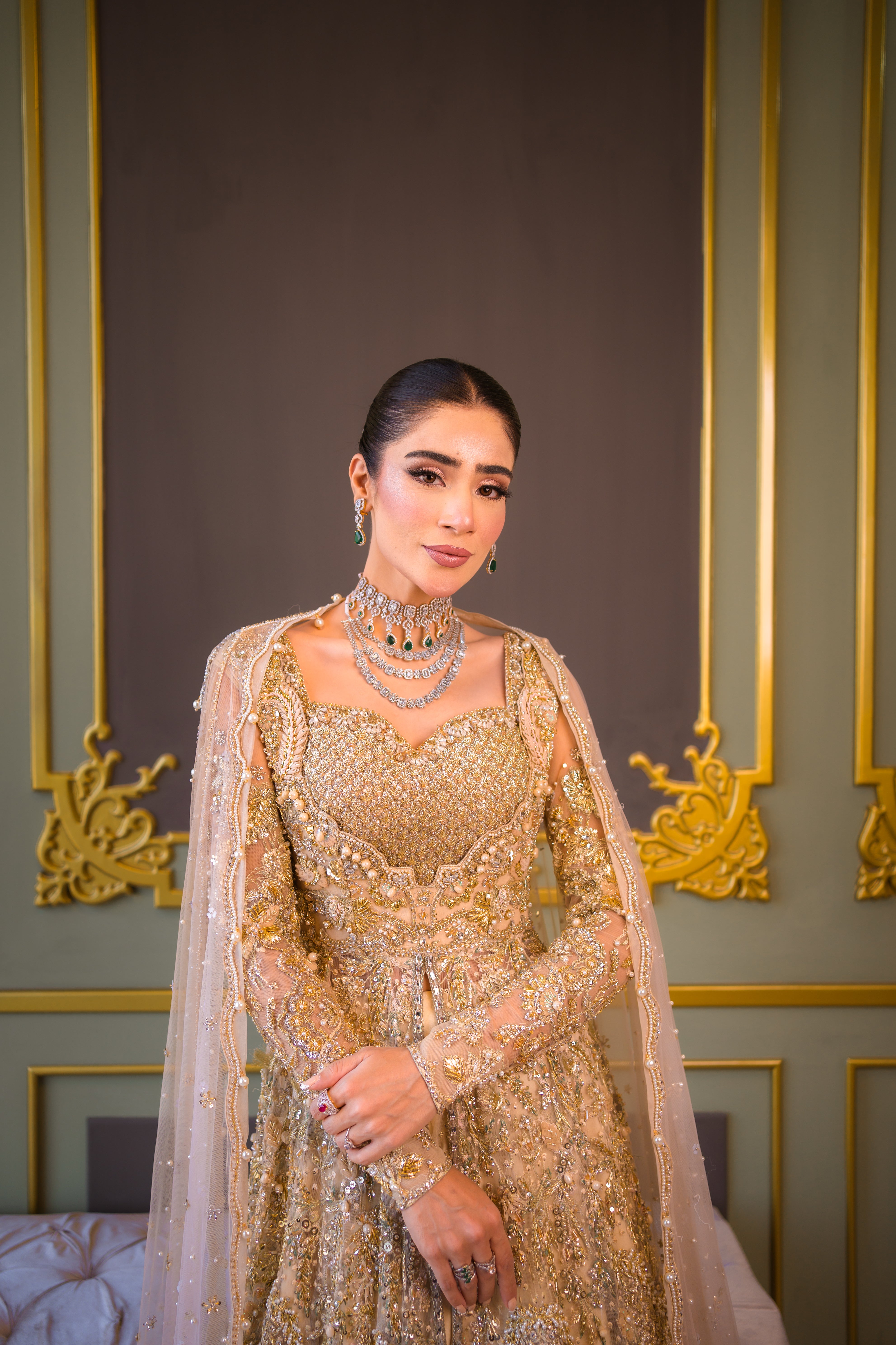 Luxury Pakistani bridal outfit Biana in subtle gold net fabric with hand embellishments.