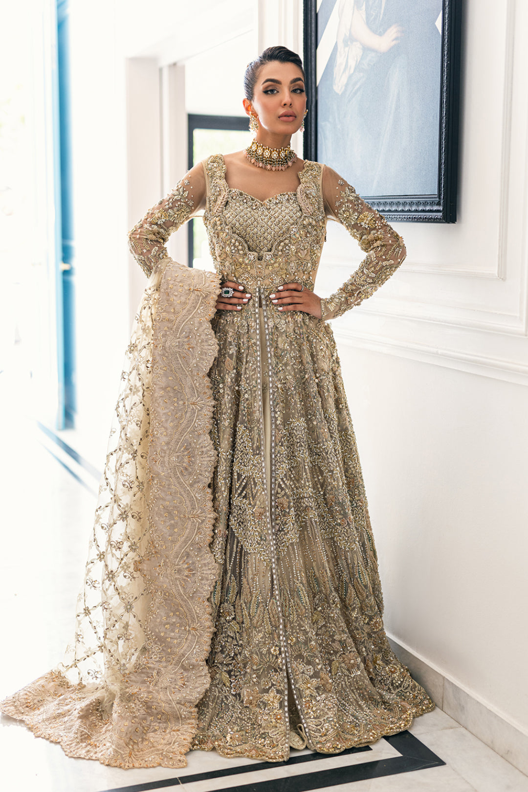 Luxury Pakistani bridal outfit Biana in subtle gold net fabric with hand embellishments.