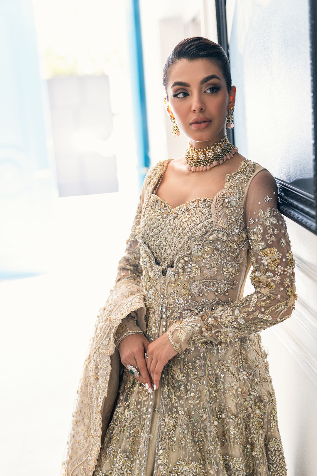 Luxury Pakistani bridal outfit Biana in subtle gold net fabric with hand embellishments.