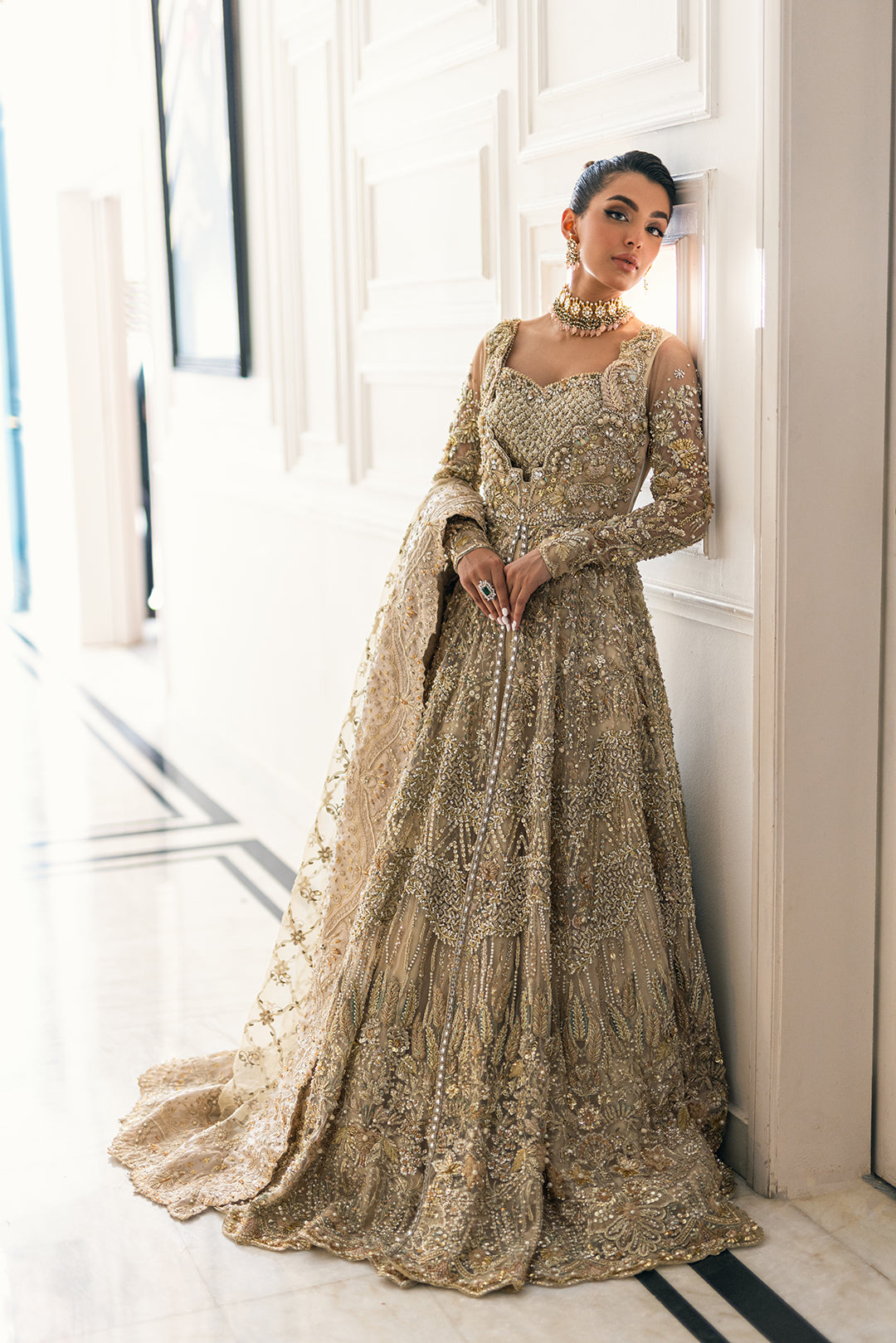 Luxury Pakistani bridal outfit Biana in subtle gold net fabric with hand embellishments.