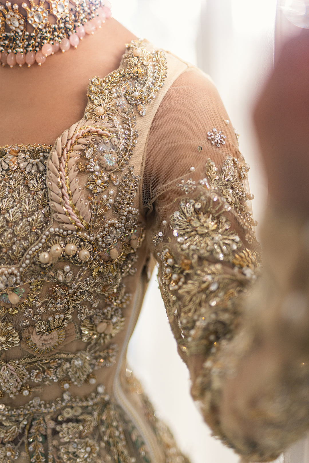 Luxury Pakistani bridal outfit Biana in subtle gold net fabric with hand embellishments.