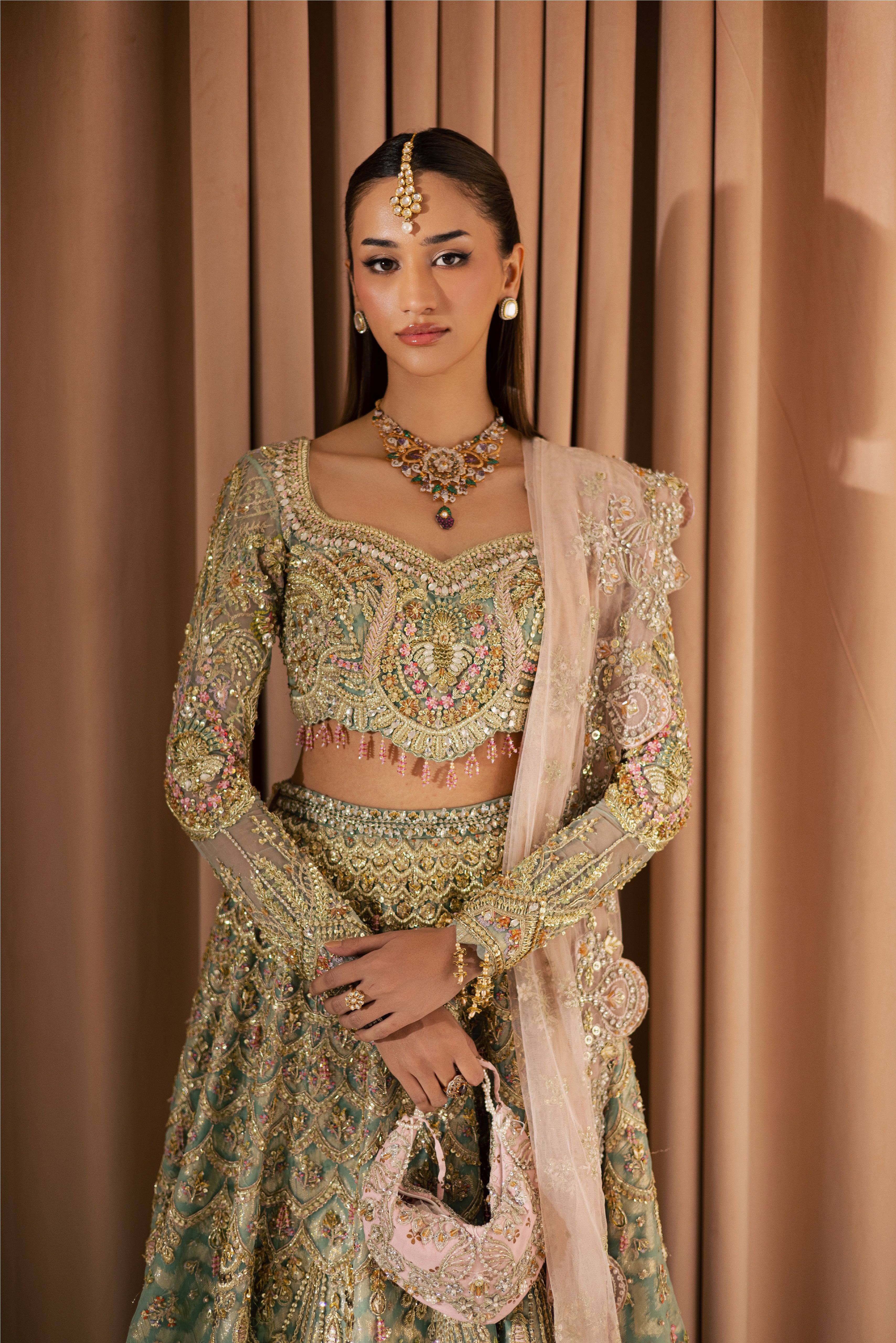 Luxury gold and pastel net Pakistani bridal lehenga by Mysie by Tahira, featuring intricate hand embellishment and couture detailing.