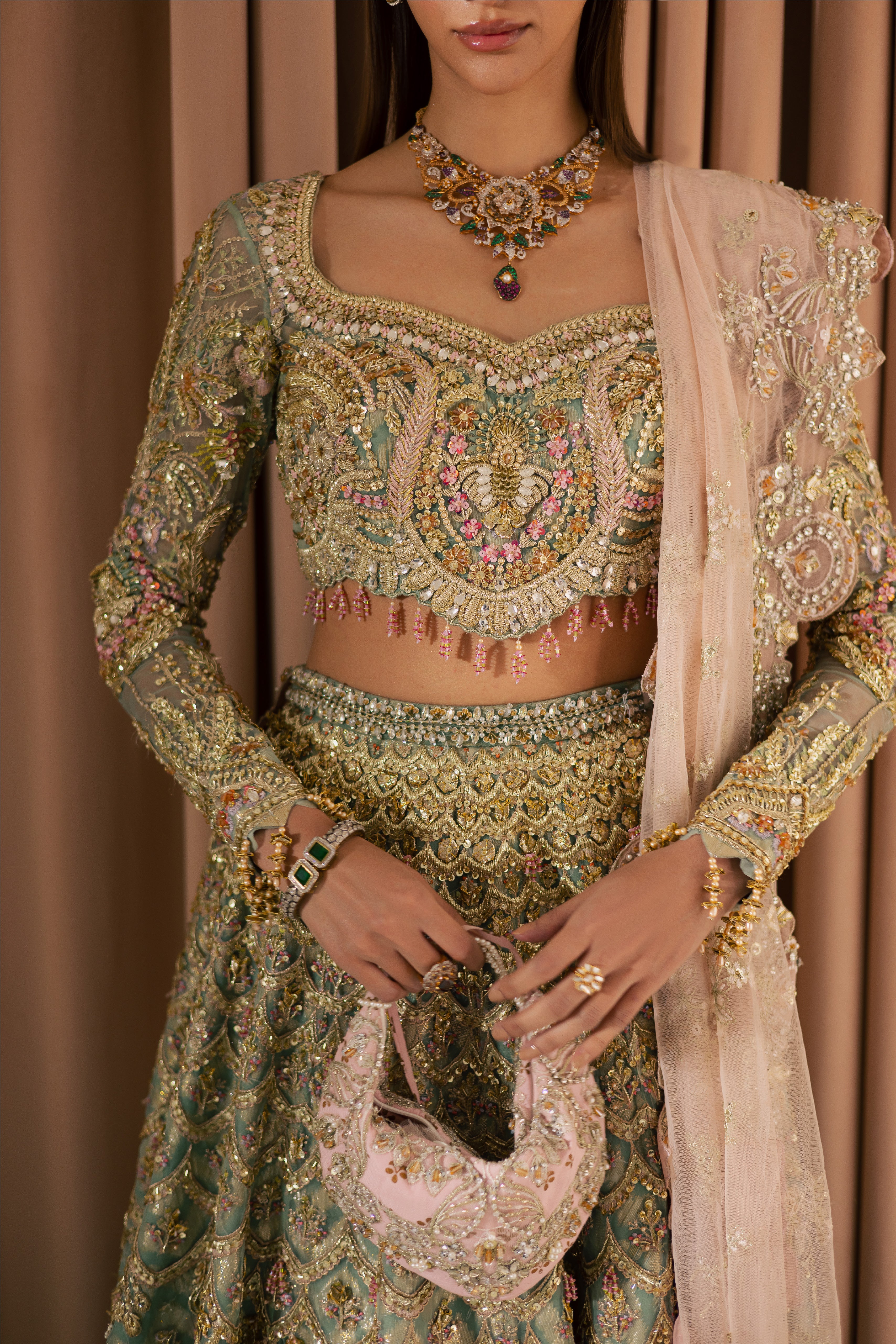 Luxury gold and pastel net Pakistani bridal lehenga by Mysie by Tahira, featuring intricate hand embellishment and couture detailing.