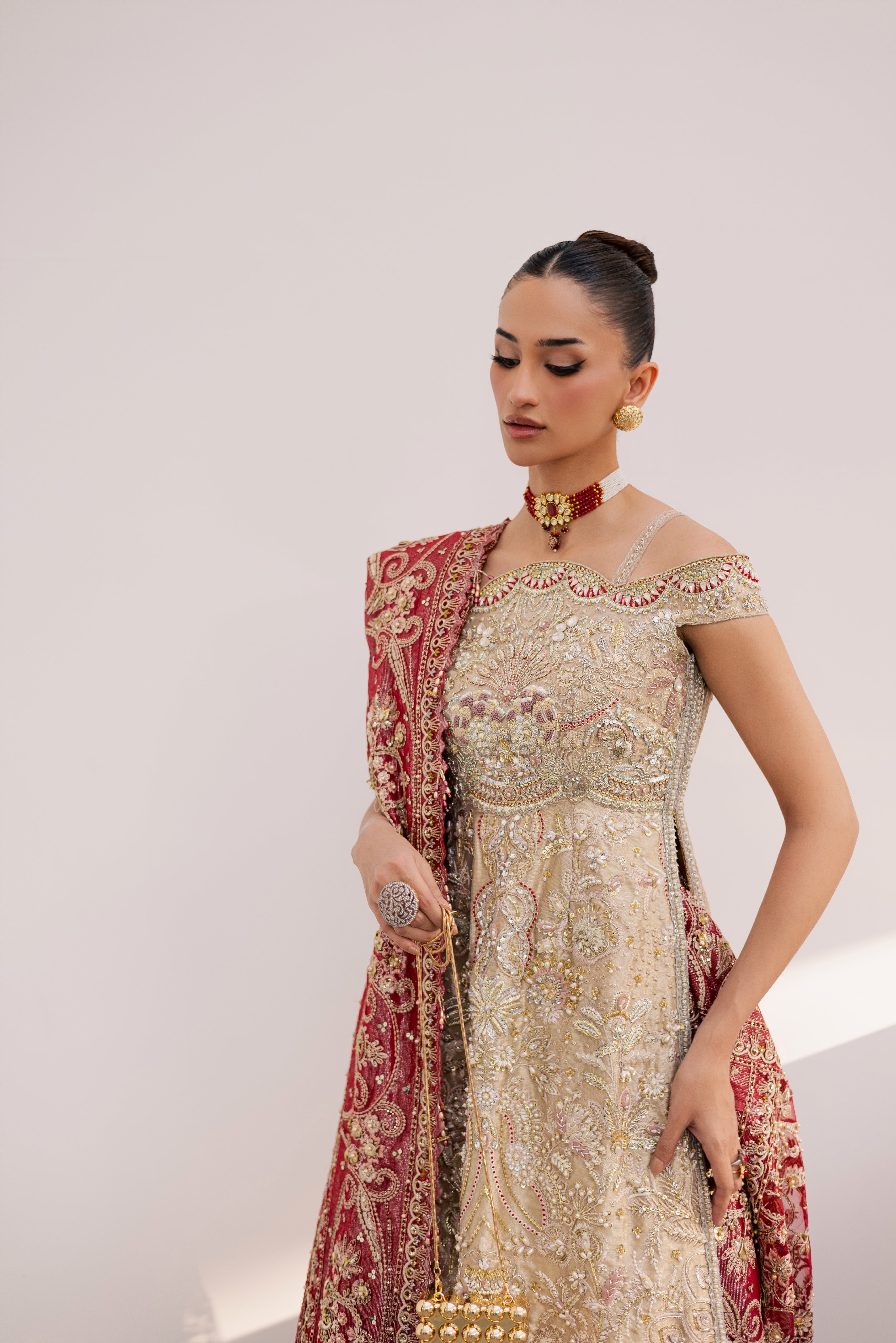 Model wearing champagne gold hand-embellished shirt and lehenga with rich maroon dupatta, luxury Pakistani couture by Mysie by Tahira.