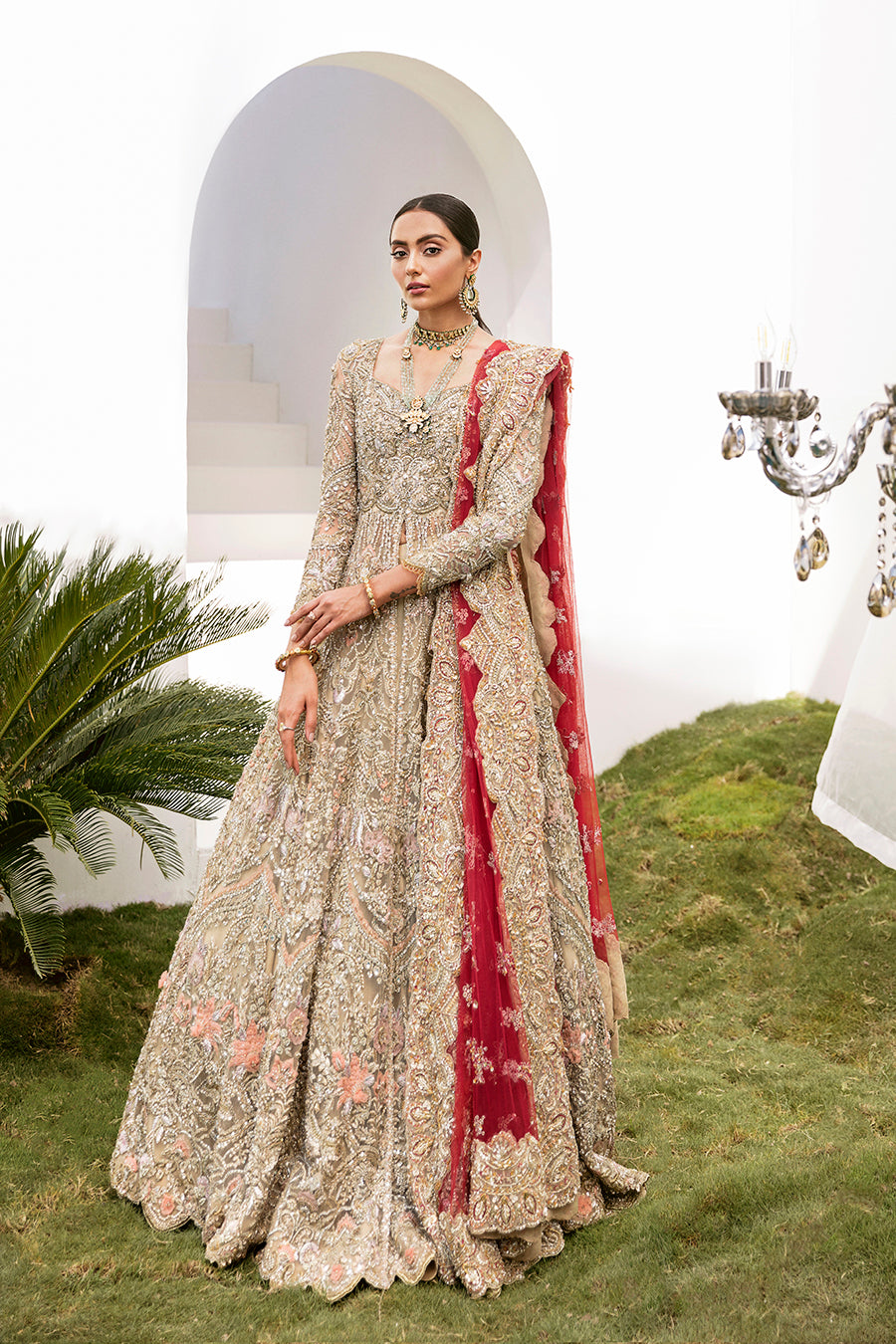 Elegant Gaia bridal gown in gold with intricate embroidery, paired with a red dupatta and raw-silk lehenga.