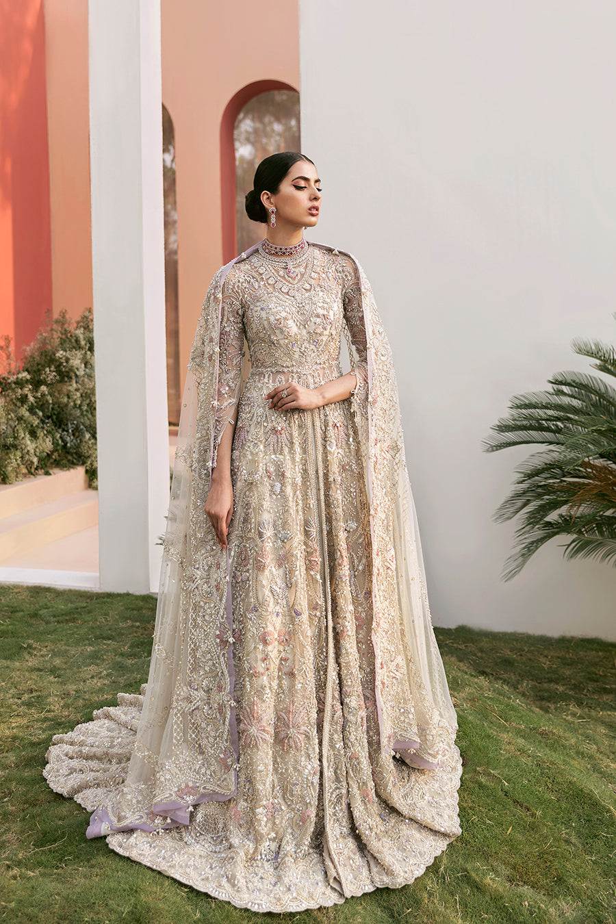 Bridal elegance in Calipso gown, showcasing the dramatic net trail, raw-silk lehenga, and lavender accents.
