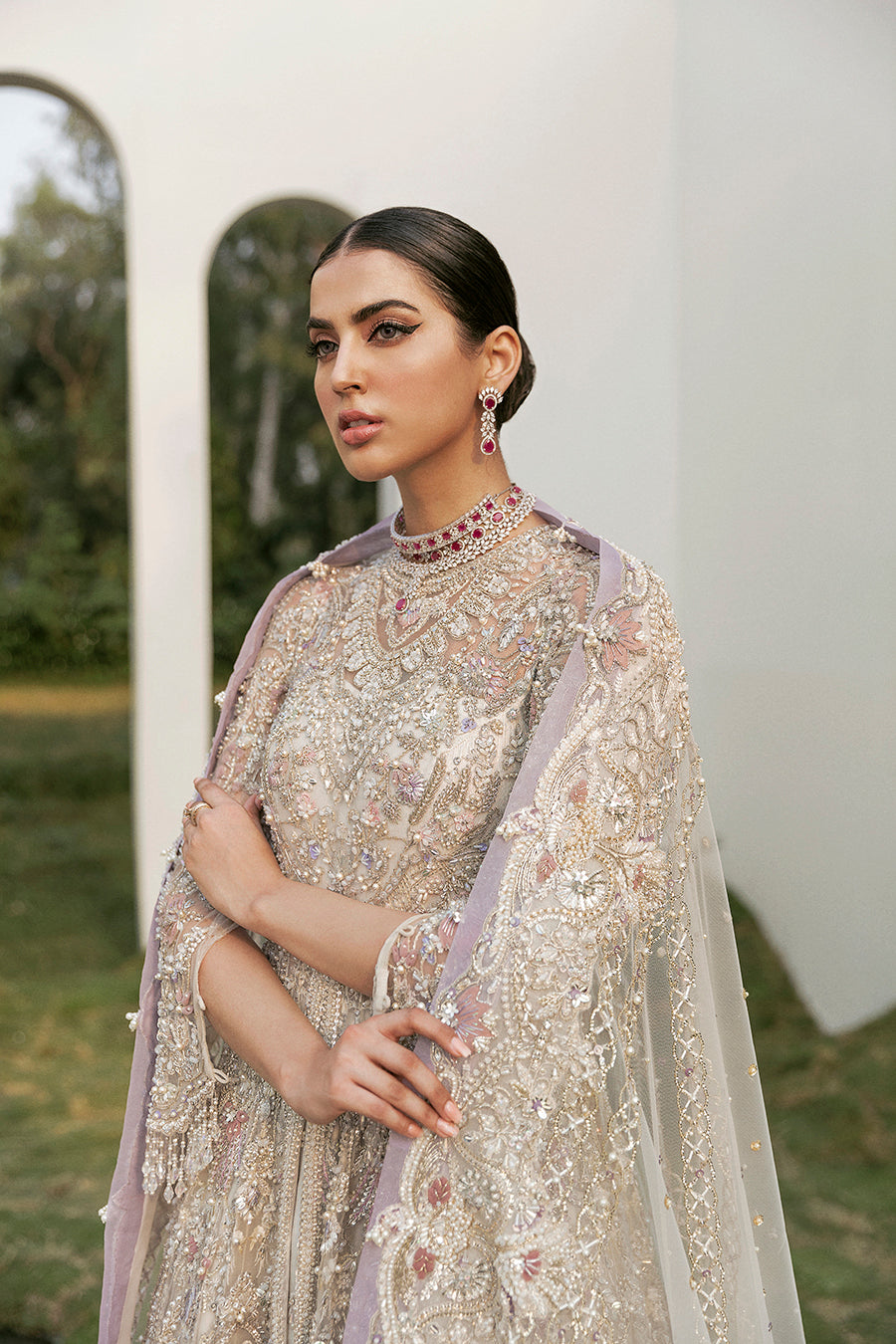 Bridal elegance in Calipso gown, showcasing the dramatic net trail, raw-silk lehenga, and lavender accents.